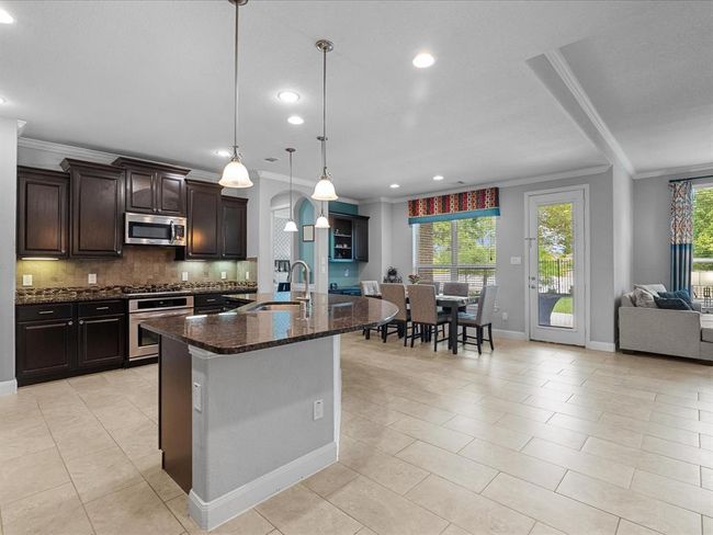 This inviting entryway features a stylish glass front door, elegant chandelier lighting, and a neutral color palette. The tile flooring complements the modern decor, while large windows allow for natural lighting. | Image 7