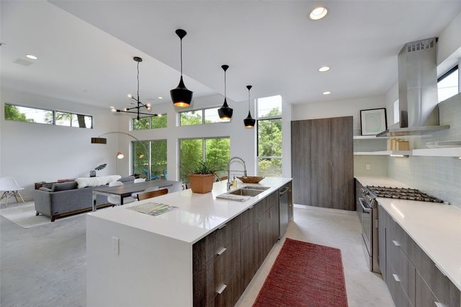 Kitchen featuring a sink, a healthy amount of sunlight, island exhaust hood, and modern cabinets | Image 9