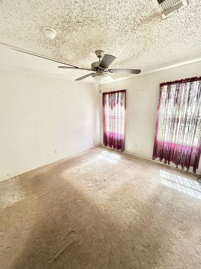 Unfurnished room featuring light carpet, a ceiling fan, and a textured ceiling | Image 14