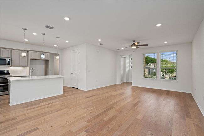This open floor plan has wood floors throughout, easy access to the kitchen/dining with a large breakfast bar. | Image 4