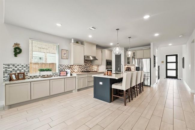 An open floorplan with low maintenance wood-look tile throughout. | Image 7