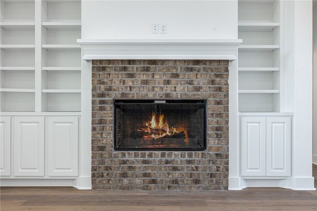 Interior details with a brick fireplace, hardwood / wood-style floors, and built in shelves | Image 8