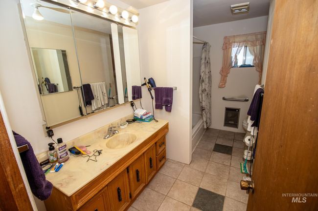 Bathroom featuring vanity, shower / tub combo, and tile patterned flooring | Image 24