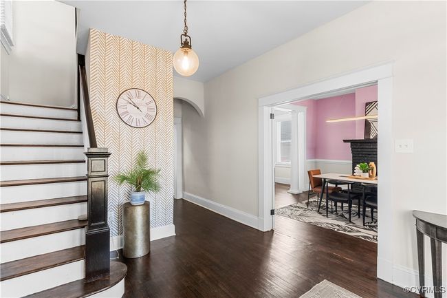 Entrance foyer featuring hardwood / wood-style flooring, baseboards, arched walkways, and stairway | Image 6
