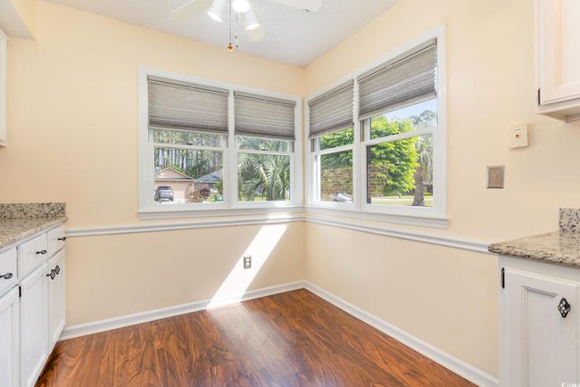 Unfurnished dining area with a ceiling fan, baseboards, and dark wood-type flooring | Image 15