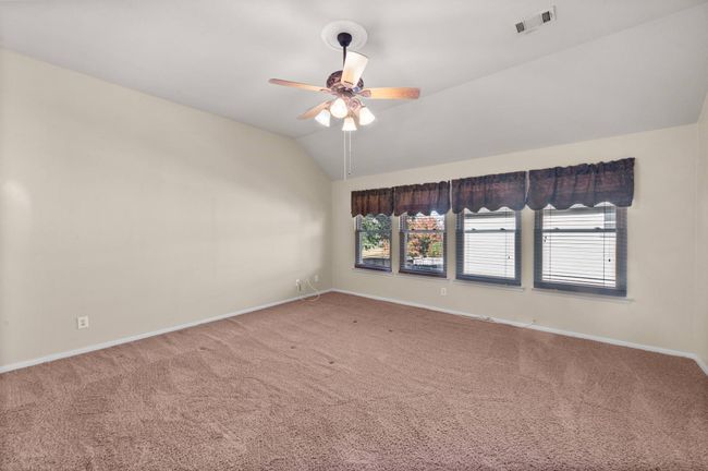 Spare room featuring carpet flooring, lofted ceiling, and a ceiling fan | Image 20