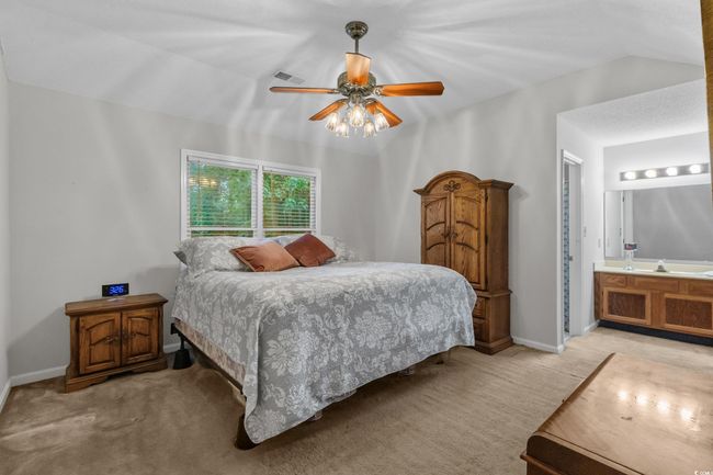 Bedroom featuring ceiling fan, lofted ceiling, and connected bathroom | Image 14