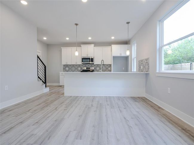 Kitchen with appliances with stainless steel finishes, tasteful backsplash, white cabinetry, recessed lighting, and pendant lighting | Image 6