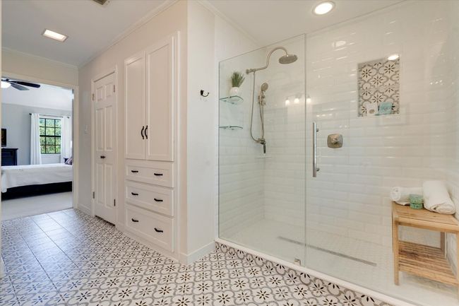 Bathroom featuring ornamental molding, a walk-in shower stall, baseboards, and storage | Image 22