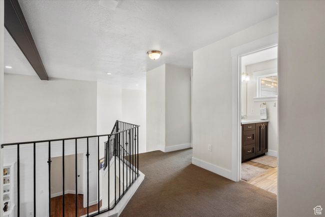 Corridor featuring light carpet, a sink, baseboards, and an upstairs landing | Image 31