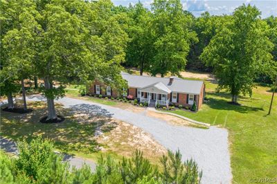 Ranch-style home with covered porch and a front lawn | Image 1