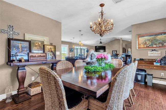 Dining room with wood finished floors, a chandelier, and baseboards | Image 22