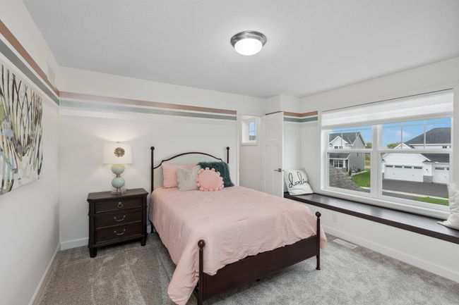 Photo is of the actual model. One of three generously sized upper-level secondary bedrooms with spacious closets. | Image 19
