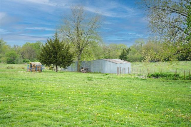 View of yard featuring fence, an outdoor structure, and a pole building | Image 27