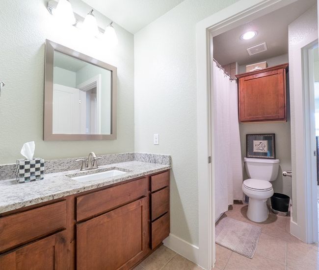 Bathroom featuring vanity, light tile patterned floors, and a textured wall | Image 21
