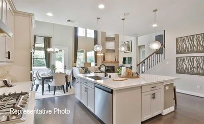 Kitchen with a kitchen island with sink, decorative light fixtures, stainless steel appliances, and dark wood-type flooring | Image 3