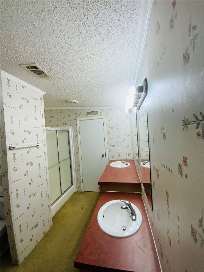 Full bathroom featuring visible vents, a sink, a textured ceiling, and a stall shower | Image 21