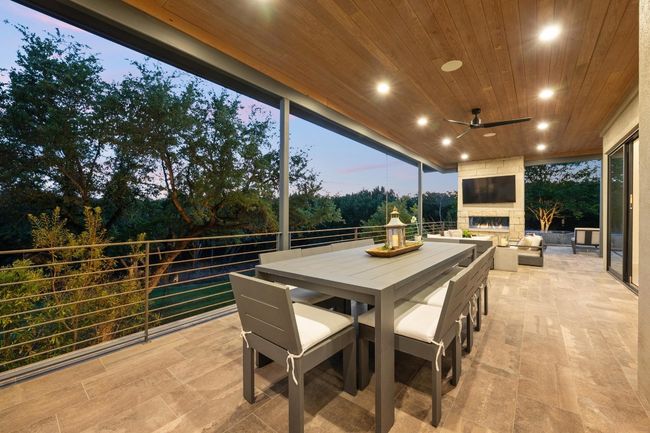 View of patio with outdoor dining space, ceiling fan, and an outdoor stone fireplace | Image 29