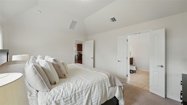 Bedroom featuring lofted ceiling, light tile patterned flooring, and light colored carpet | Image 28