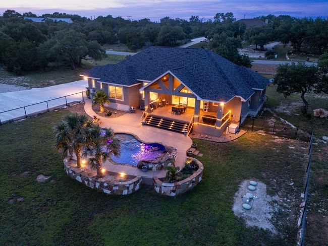 Rear view of property featuring a covered patio area and an outdoor fire pit | Image 11