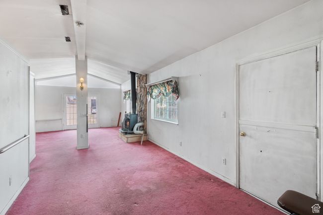 Large Primary suite or additional living room with a wood stove, plenty of natural light, and carpet | Image 14