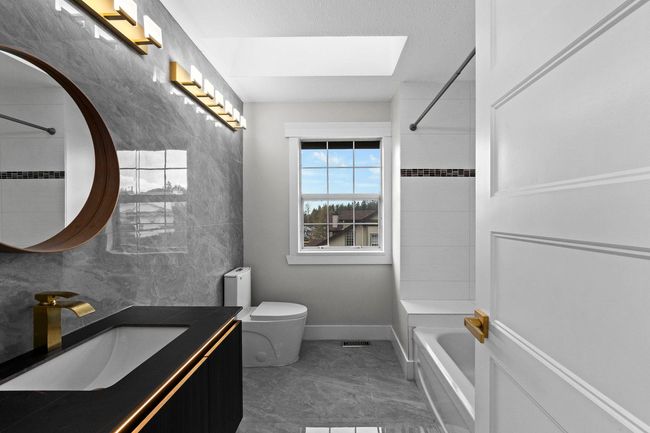 Bathroom featuring bathtub / shower combination, vanity, visible vents, toilet, and a skylight | Image 28