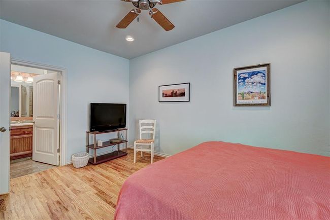 Bedroom with recessed lighting, wood finished floors, a ceiling fan, connected bathroom, and baseboards | Image 31