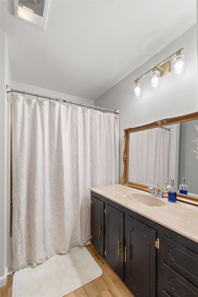 Bathroom with wood finished floors, vanity, and a shower with curtain | Image 24
