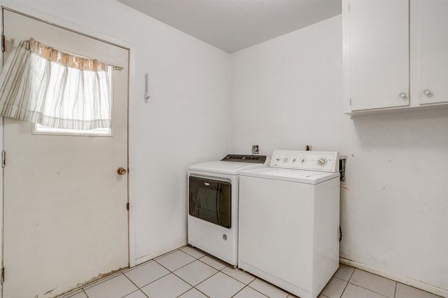 spacious utility room with built-in cabinet and access to the garage and backyard. Washer and dryer - convey with the home | Image 22