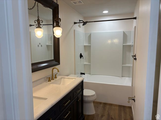 Full bathroom with wood finished floors, toilet, double vanity, and washtub / shower combination | Image 14