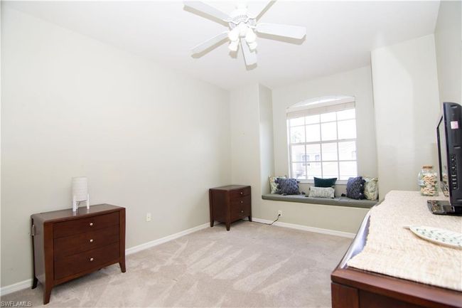 Bright and spacious second bedroom features a double closet and charming window seat. | Image 17