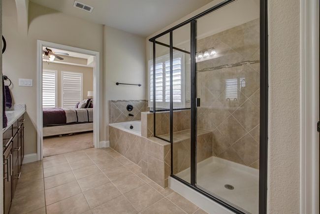 Ensuite bathroom featuring tile patterned flooring, a garden tub, a stall shower, a ceiling fan, and vanity | Image 17