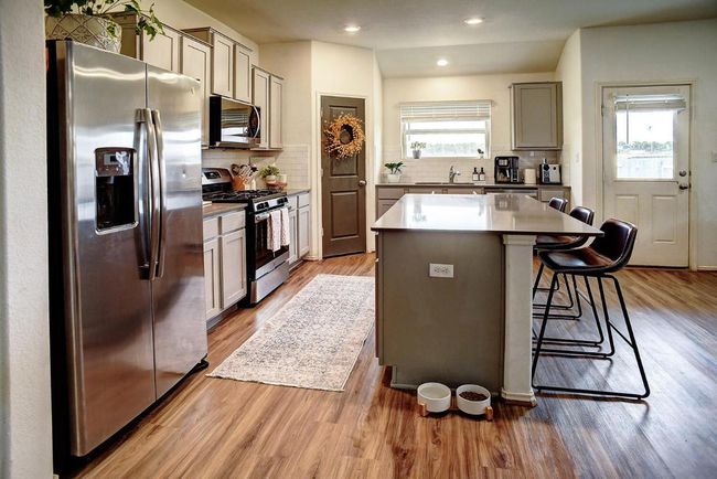 Kitchen with wood finished floors, a sink, a wealth of natural light, and appliances with stainless steel finishes | Image 12