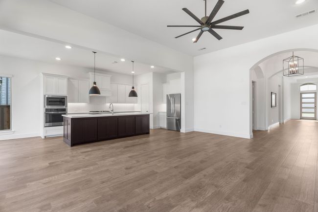 Kitchen with appliances with stainless steel finishes, open floor plan, ceiling fan, light countertops, and backsplash | Image 23