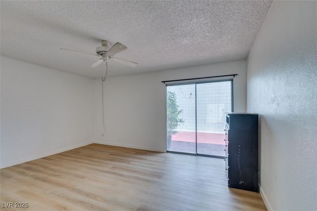 Spare room with a textured ceiling, wood finished floors, ceiling fan, and a textured wall | Image 30