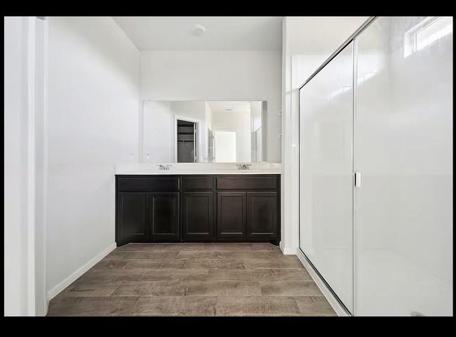 Full bath with wood finished floors, double vanity, and a stall shower | Image 7