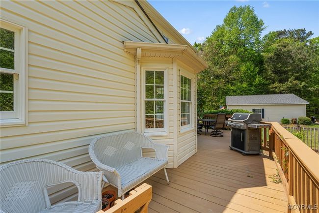Wooden deck with a grill and outdoor dining space | Image 10