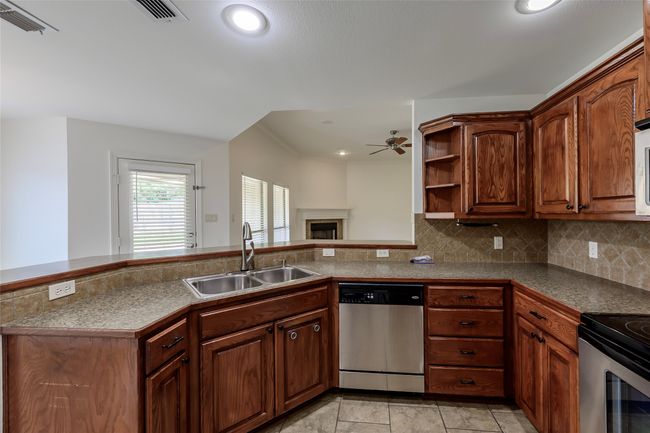 Kitchen featuring ceiling fan, appliances with stainless steel finishes, tasteful backsplash, and a sink | Image 23