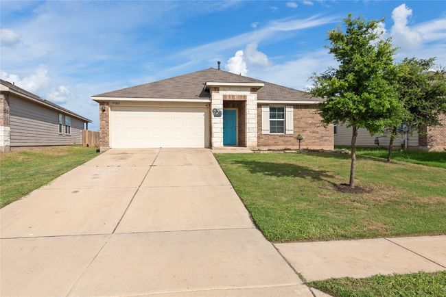 Ranch-style home featuring concrete driveway, brick siding, an attached garage, a front lawn, and roof with shingles | Image 25