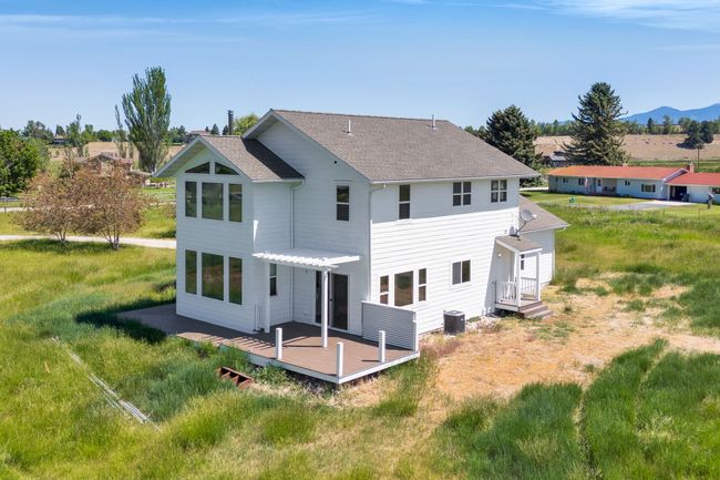 Rear view of property with a pergola, a deck with mountain view, roof with shingles, and central AC unit | Image 52