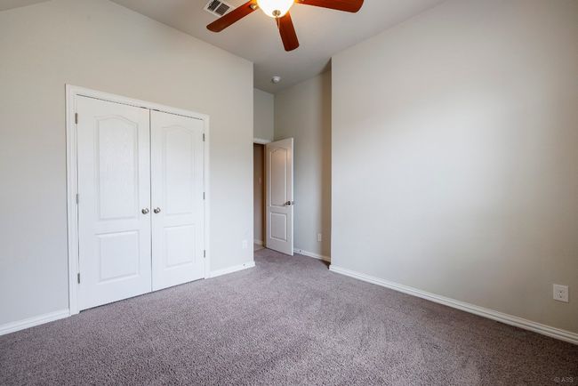 Unfurnished bedroom featuring carpet, a closet, and a ceiling fan | Image 22