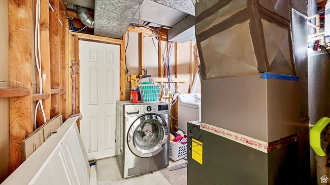 Laundry room featuring heating unit, independent washer and dryer, and laundry area | Image 23