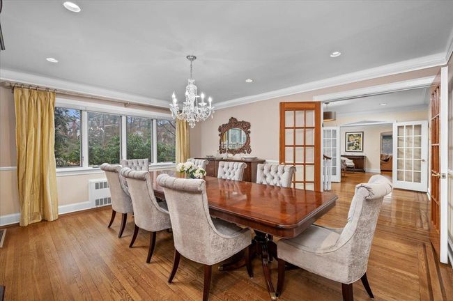 Dining area featuring french doors, wood-flooring, ornamental molding, and a chandelier | Image 4