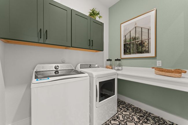 The laundry room includes built-in cabinetry for organization and storage. | Image 16