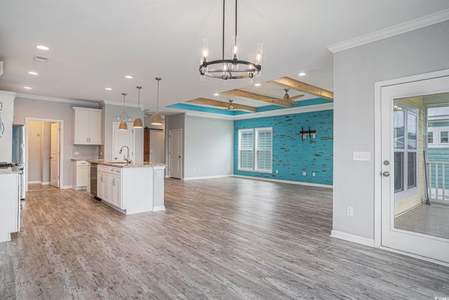 Kitchen featuring crown molding, open floor plan, recessed lighting, a chandelier, and a kitchen island with sink | Image 10
