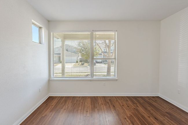 Empty room featuring dark wood-style flooring, baseboards, and a healthy amount of sunlight | Image 18