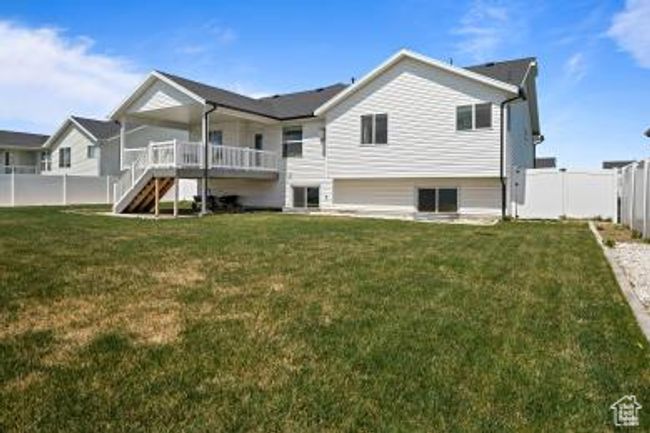 Back of property featuring a yard, a fenced backyard, stairway, and a deck | Image 35