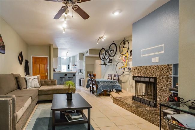 Living area with a ceiling fan, a fireplace, and light tile patterned flooring | Image 7