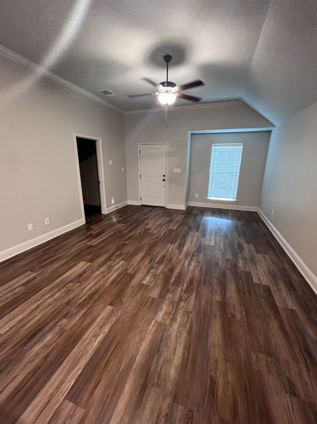 Additional living space with ceiling fan, dark wood-type flooring, baseboards, lofted ceiling, and a textured ceiling | Image 30