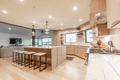 Kitchen with hanging light fixtures, light hardwood / wood-style flooring, plenty of natural light, and light brown cabinets | Image 2